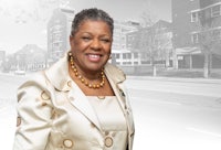 a woman in a suit standing in front of a street